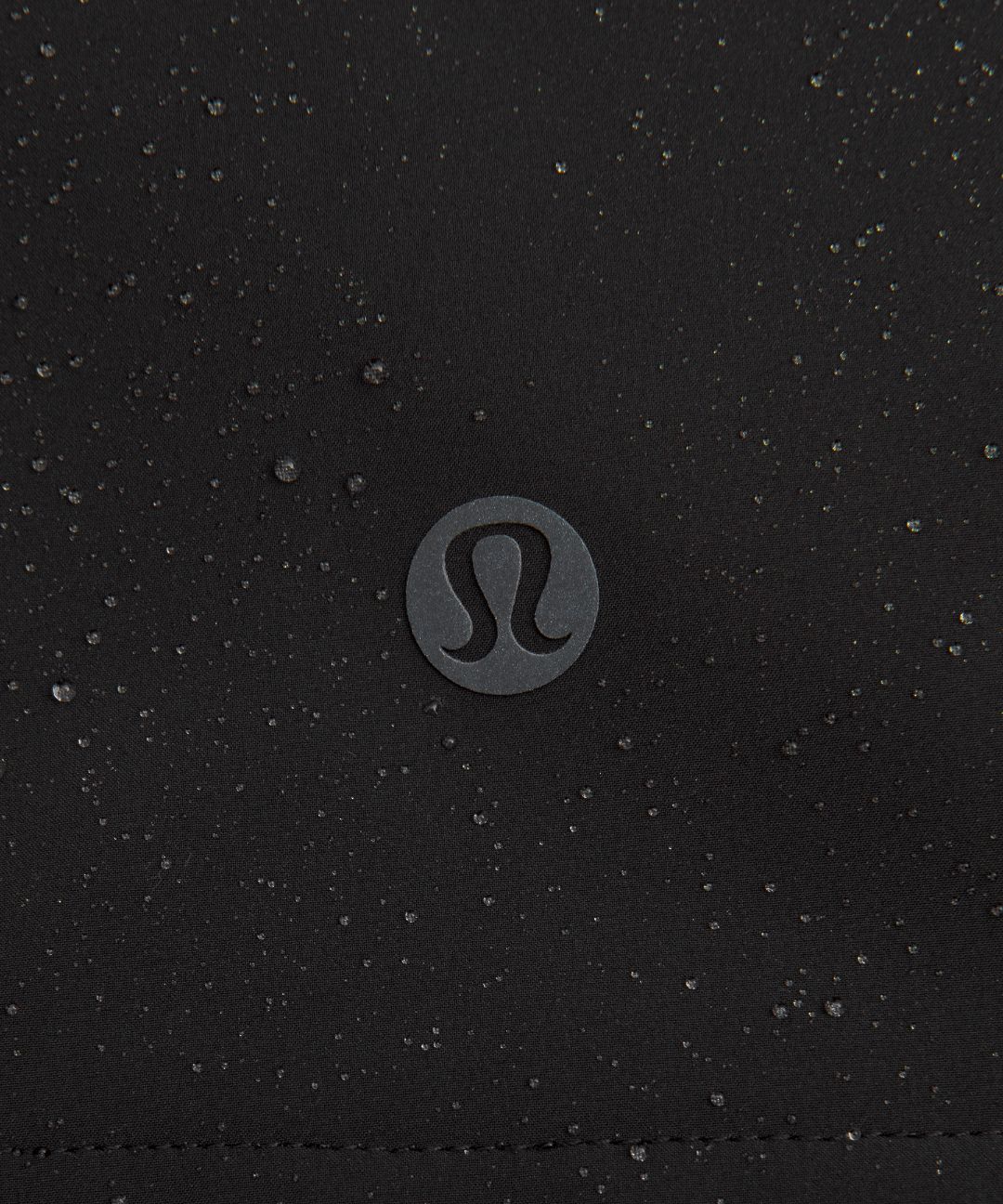 Close-up of a black textured surface with a Lululemon logo in the center.