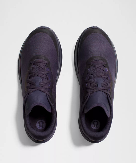 Pair of dark purple athletic shoes on a light gray background