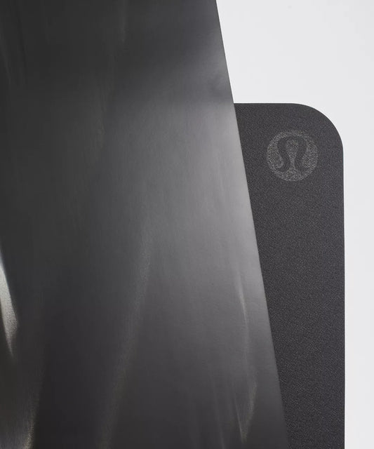 Black yoga mat with a brand logo on a light gray background