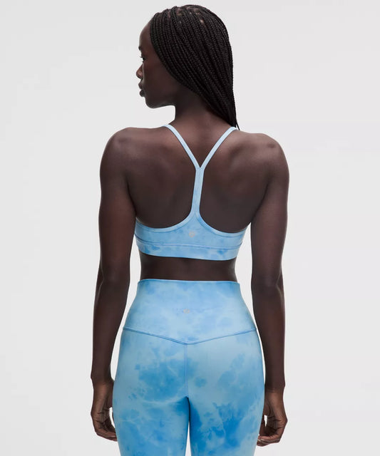 Person wearing a blue tie-dye sports bra and leggings on a light gray background