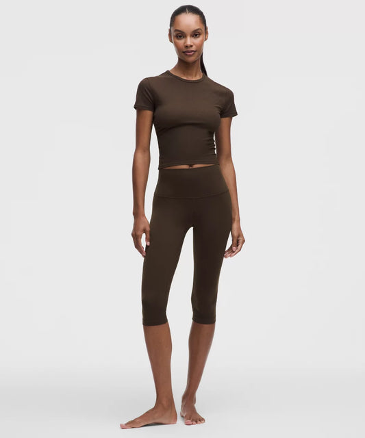 Woman wearing a brown athletic outfit on a white background