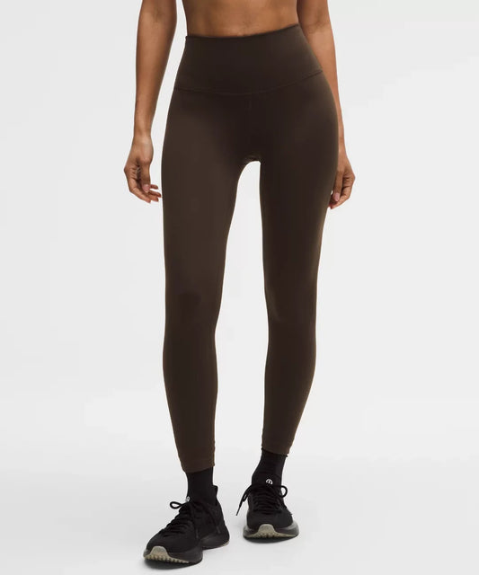 Person wearing brown leggings on a white background