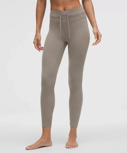Beige leggings worn by a person on a white background