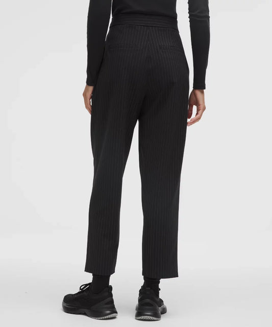 Person wearing black ribbed knit pants on a white background