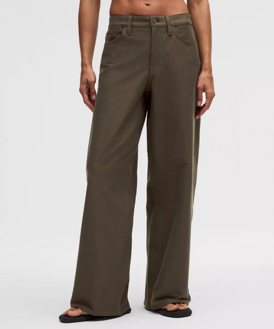 Person wearing brown wide-leg pants on a white background