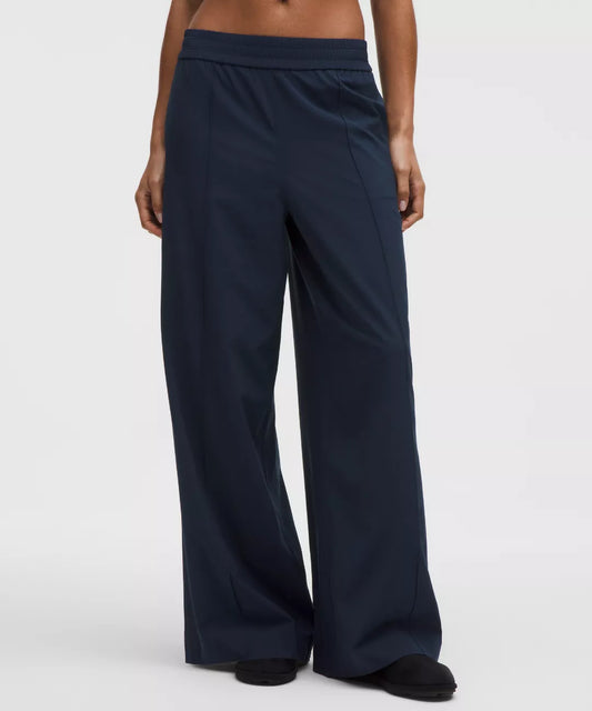 Navy blue wide-leg pants worn by a person on a white background