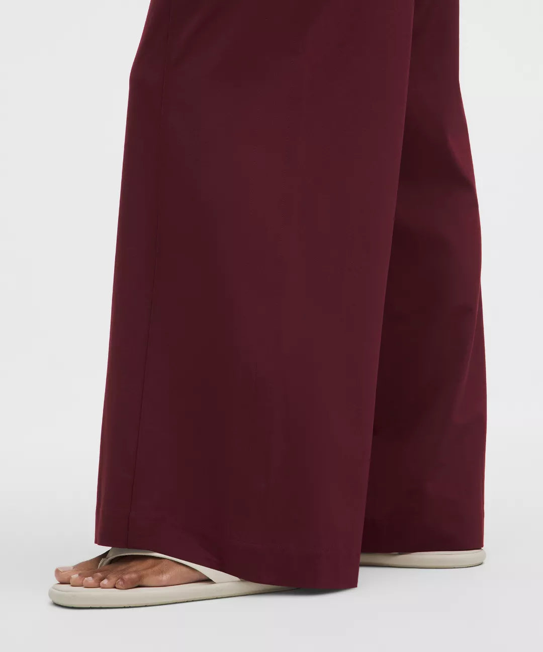 Maroon pants worn by a person on a white background