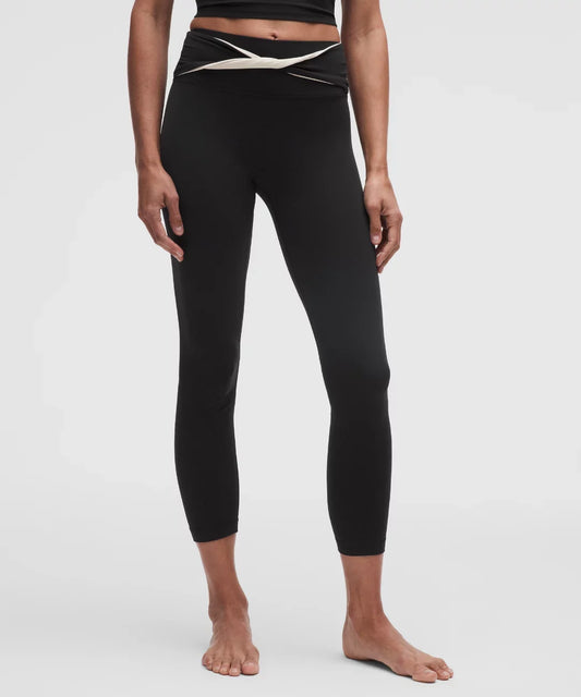 Person wearing black leggings with a white waistband on a white background