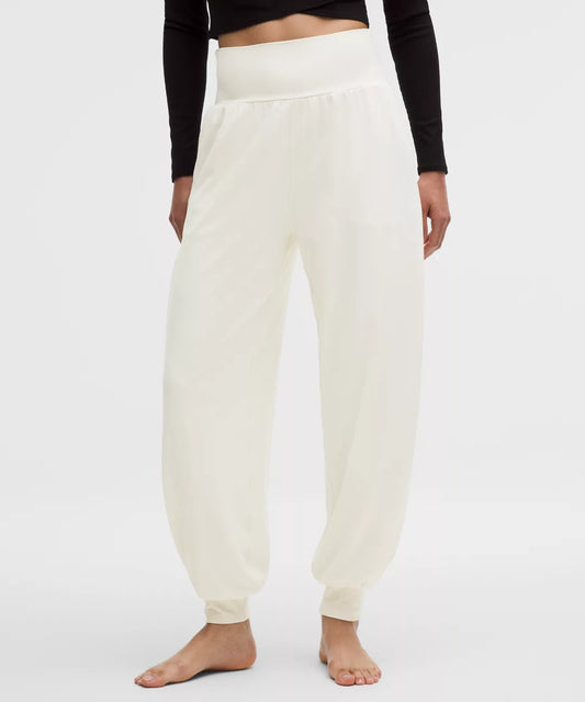 Person wearing white sweatpants on a plain background