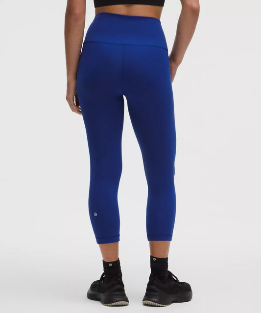 Person wearing blue leggings on a white background
