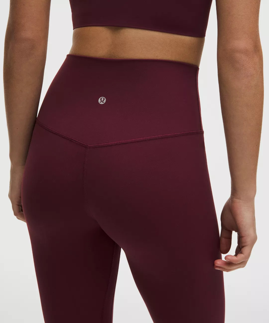 Maroon athletic leggings with a brand logo on a white background