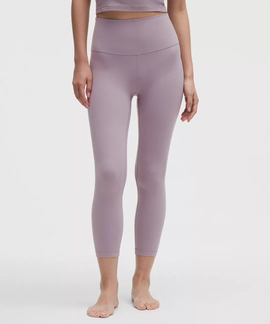 Person wearing purple leggings on a white background
