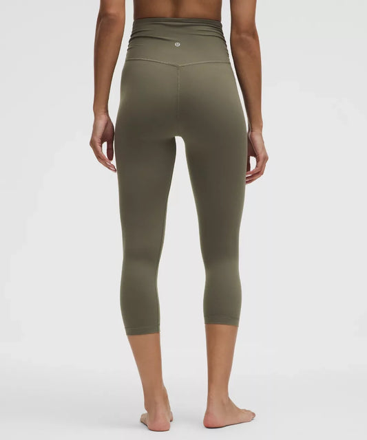 Person wearing olive green leggings on a white background