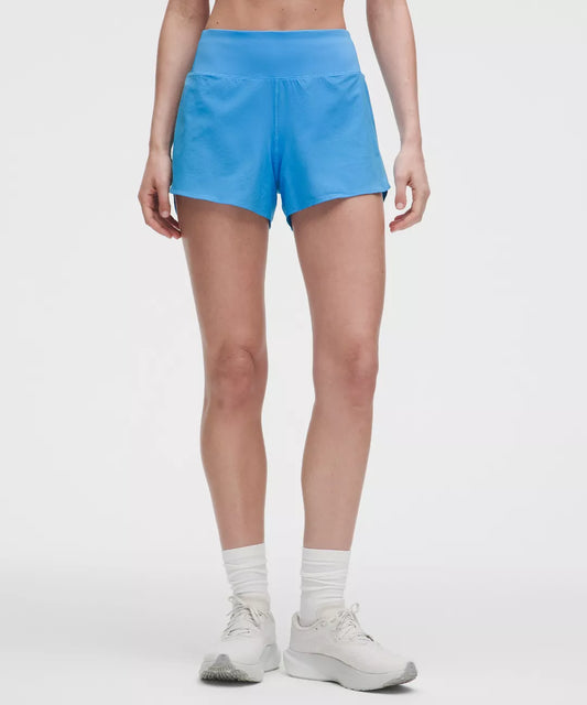 Person wearing blue athletic shorts on a white background