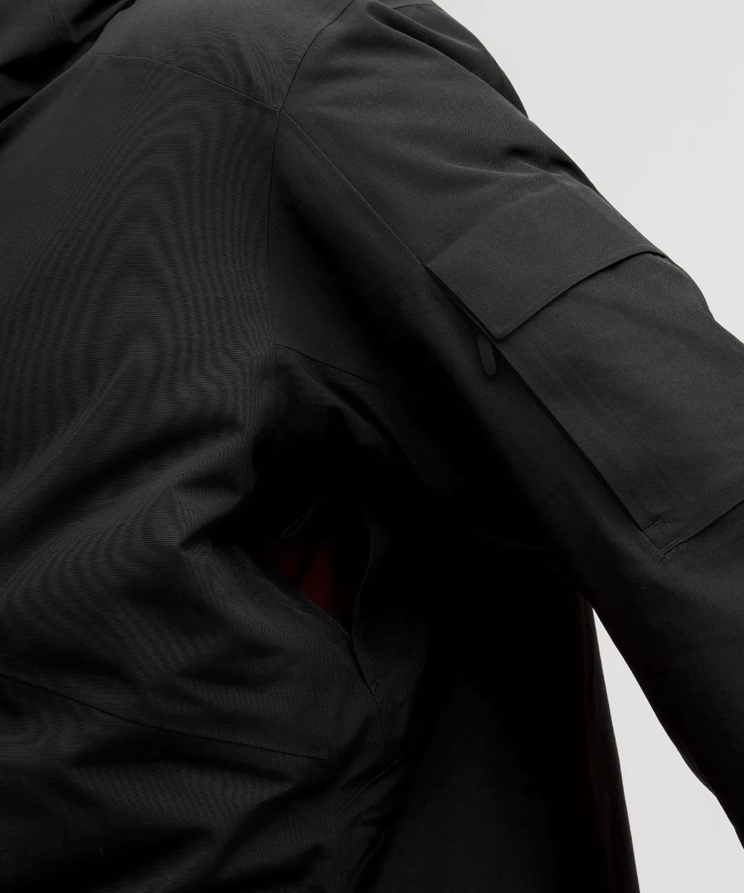 Close-up of a black jacket with a pocket on a light gray background