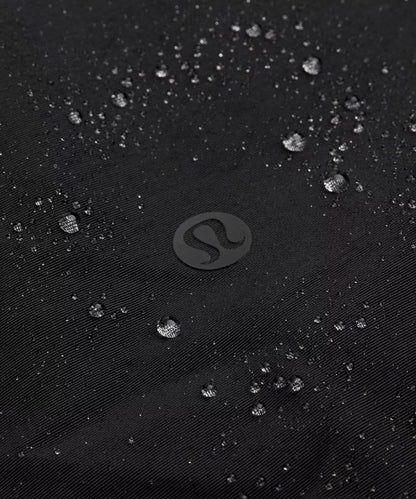 Close-up of water droplets on a black textured surface with a brand logo.