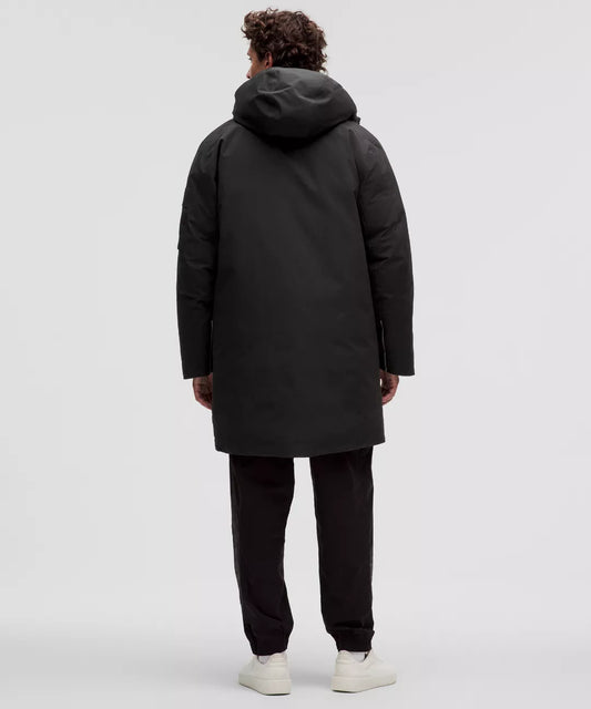 Person wearing a black coat and pants on a white background