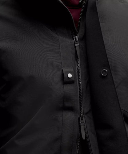 Close-up of a black jacket with a zipper and buttons.