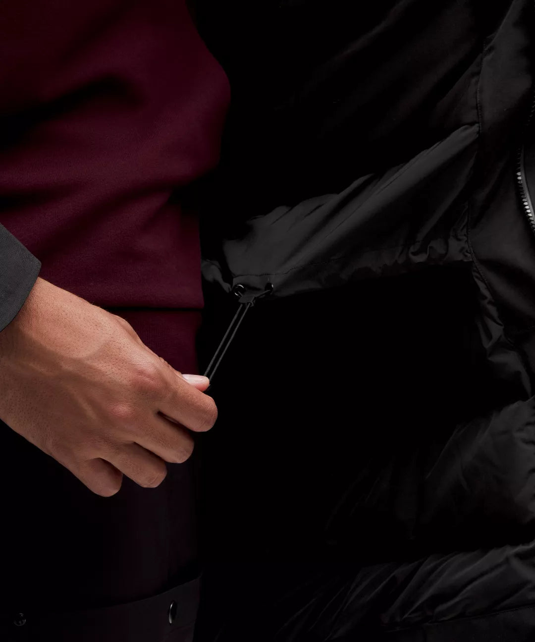 Person holding a black umbrella with a dark background