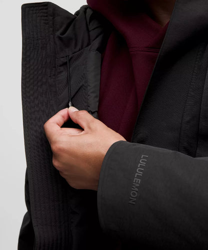 Person wearing a black Lululemon jacket with a close-up of the brand logo.