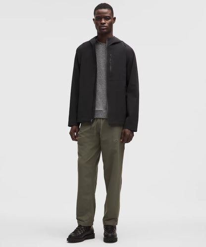 Man wearing a black jacket and green pants on a white background