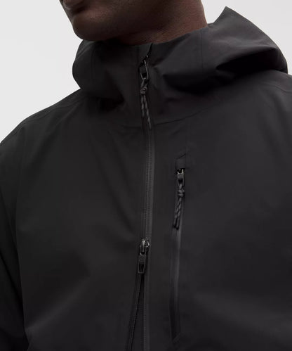 Close-up of a black jacket with a hood and zipper on a neutral background