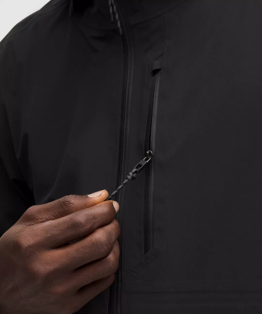 Close-up of a person zipping up a black jacket