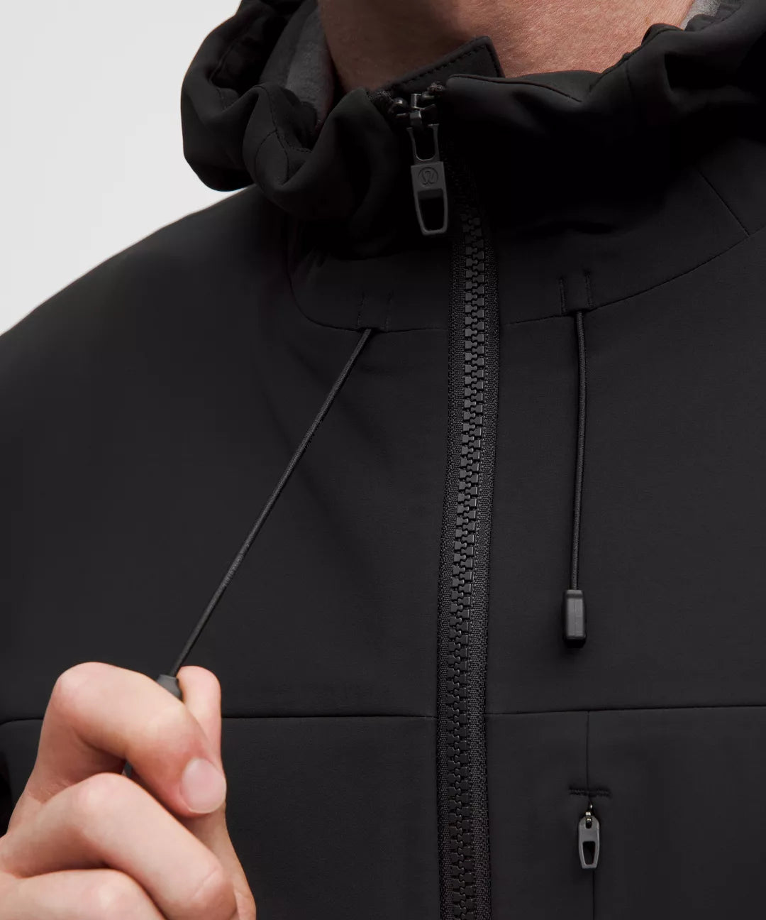 Close-up of a black jacket with a zipper on a light gray background