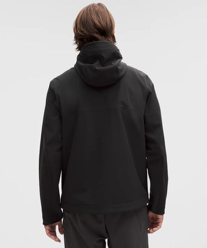 Person wearing a black hoodie and pants on a light gray background