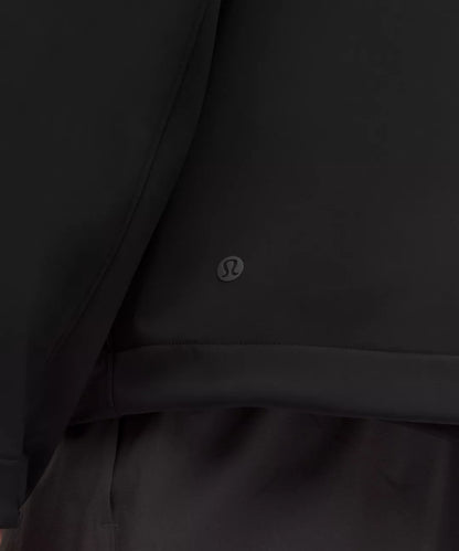 Close-up of a black jacket with a visible brand logo on a dark background