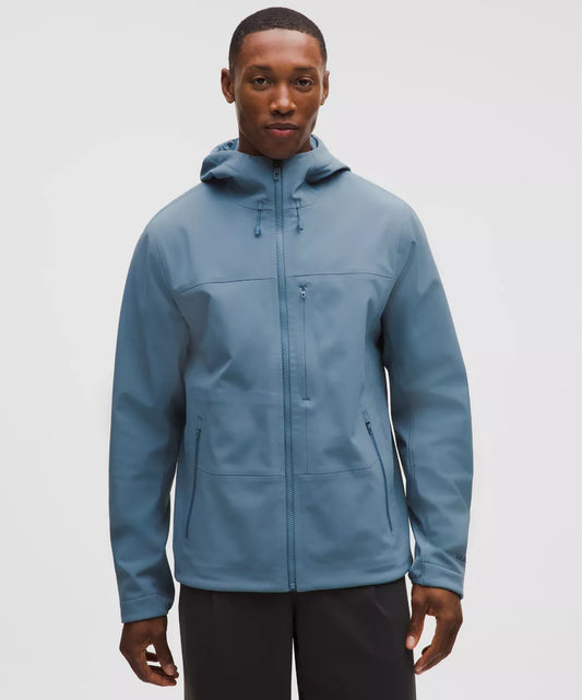 Man wearing a blue jacket on a light gray background