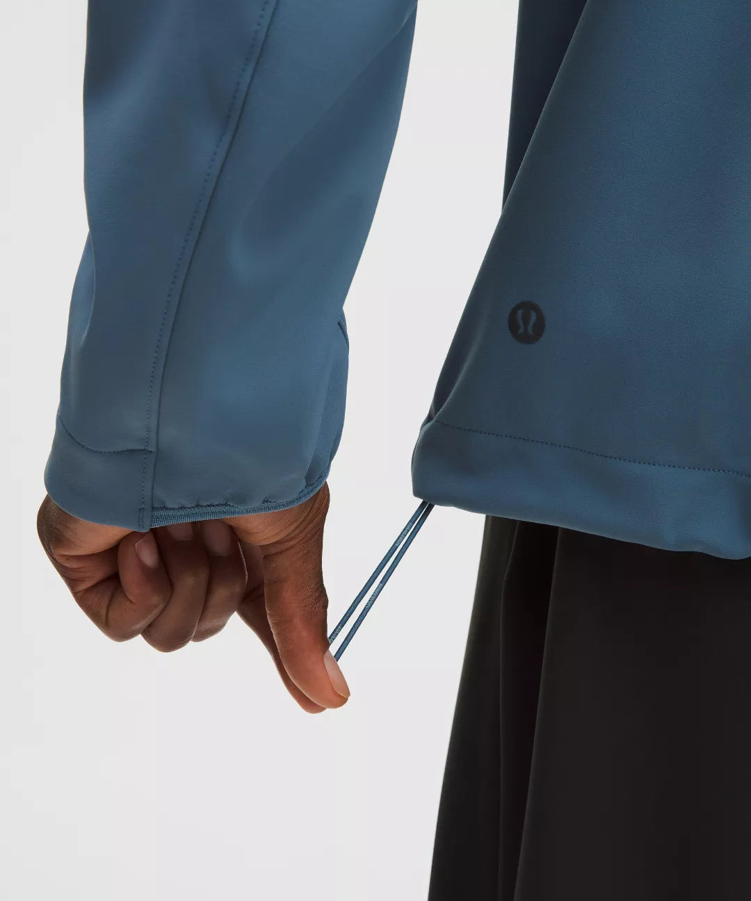 Close-up of a person wearing a blue jacket with a white background