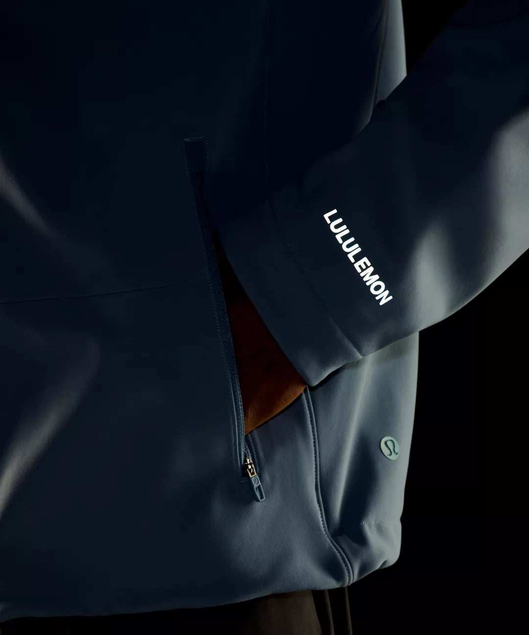 Dark blue jacket with Lululemon branding on a black background