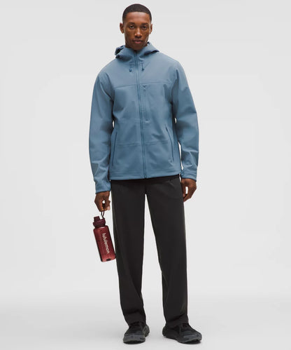 Person wearing a blue jacket holding a red water bottle on a white background