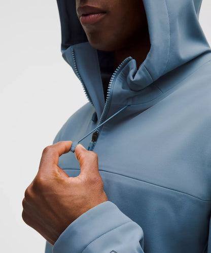 Person wearing a light blue jacket with a hood, focusing on the zipper area.