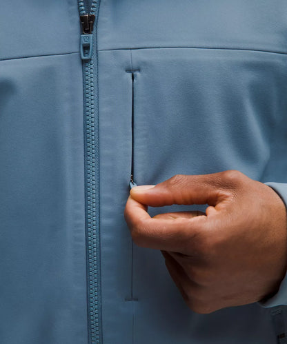 Hand zipping a blue jacket