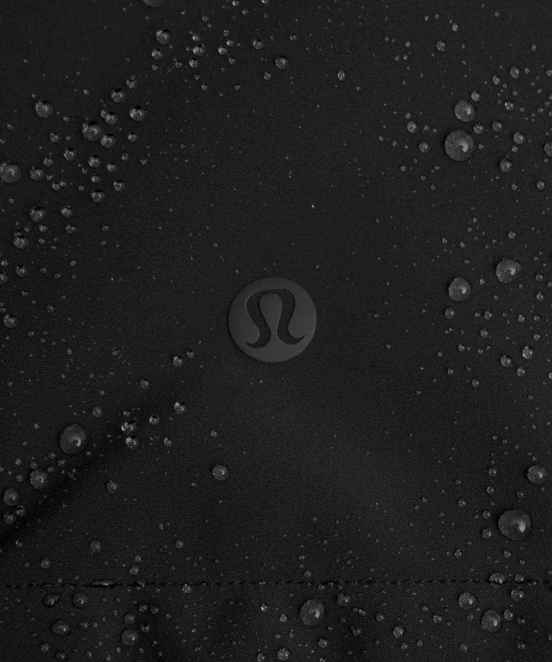 Close-up of a black surface with water droplets and Lululemon logo.