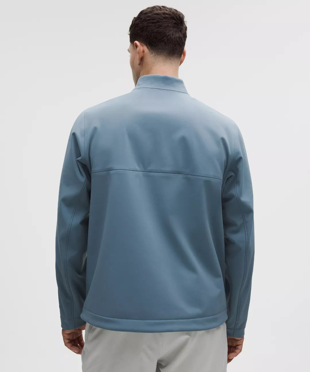 Man wearing a blue jacket on a light gray background