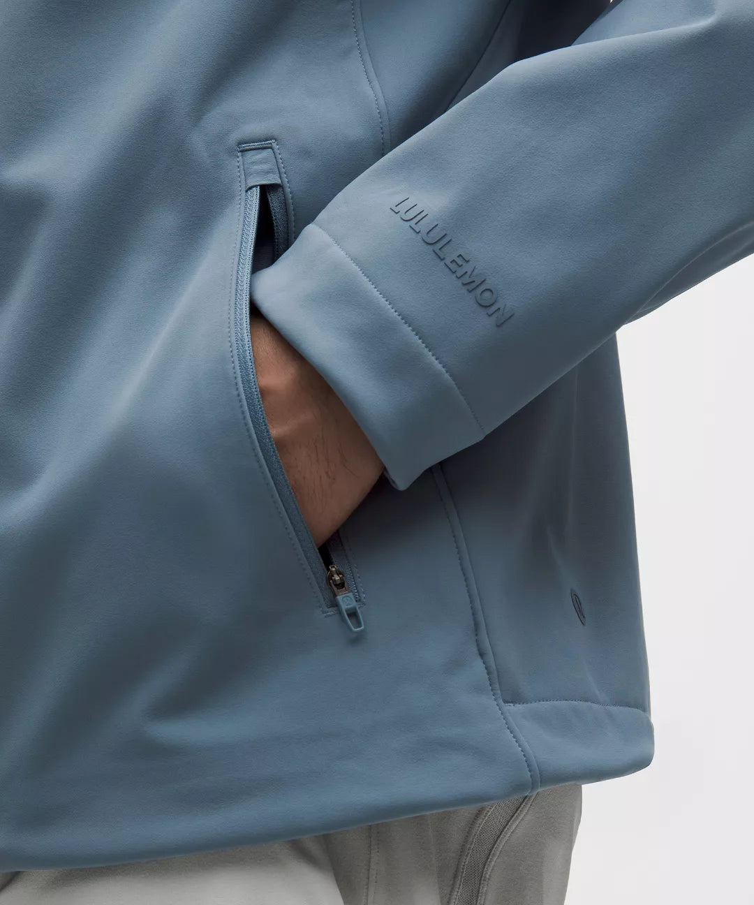 Close-up of a blue jacket with a brand logo on a white background