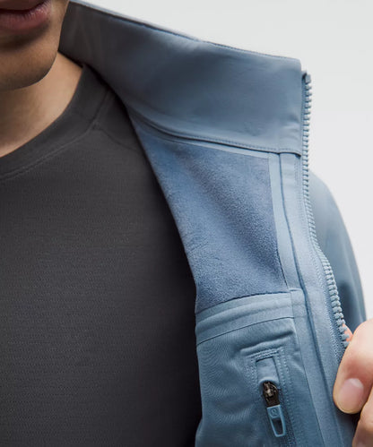 Close-up of a person wearing a light blue jacket with a zipper, focusing on the jacket's texture and design.