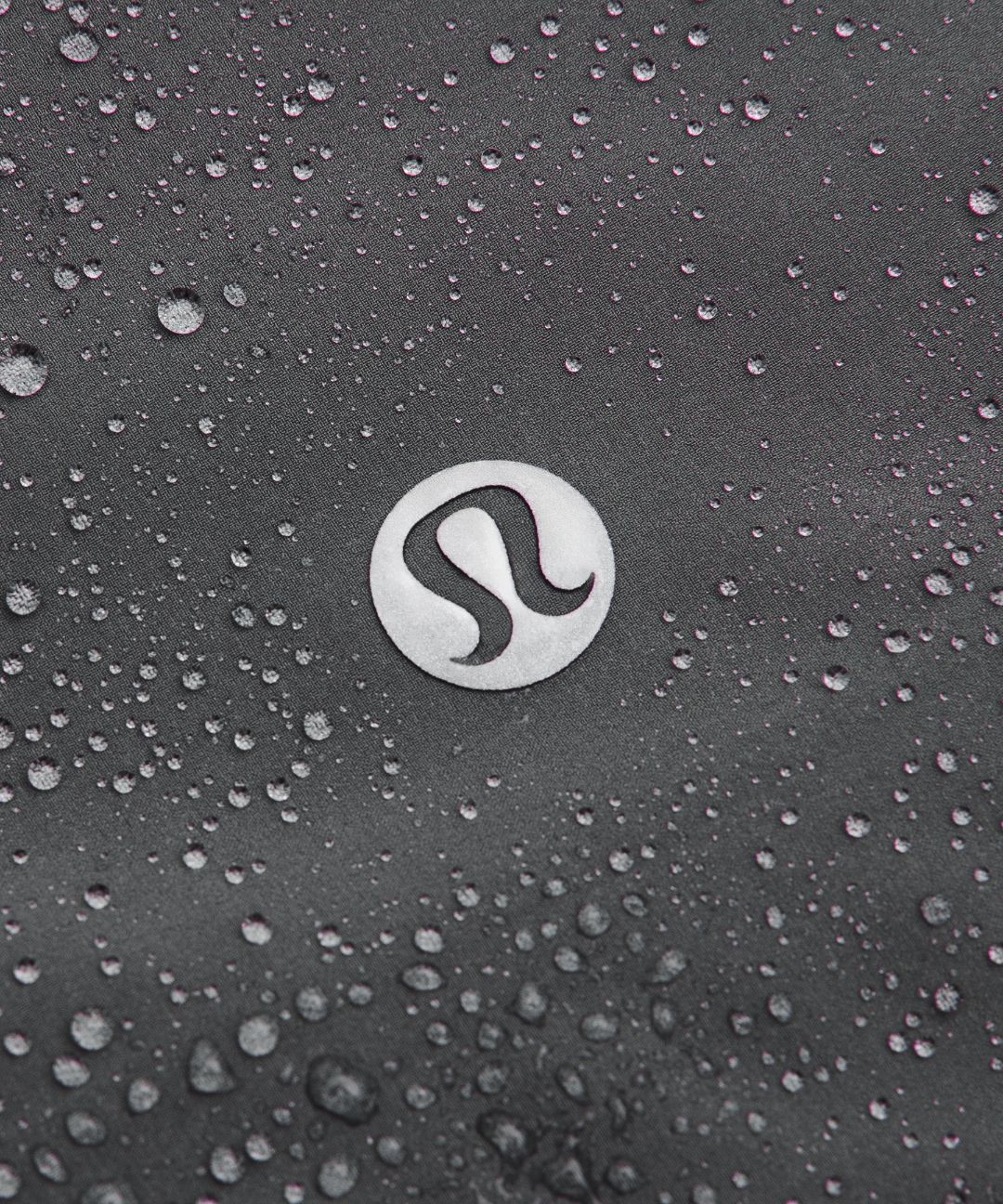 Close-up of a logo on a textured surface with water droplets.