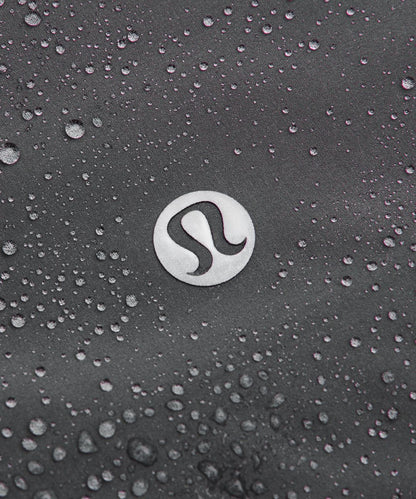 Close-up of a logo on a textured surface with water droplets.