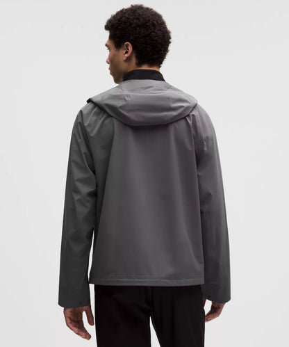 Person wearing a gray raincoat on a white background