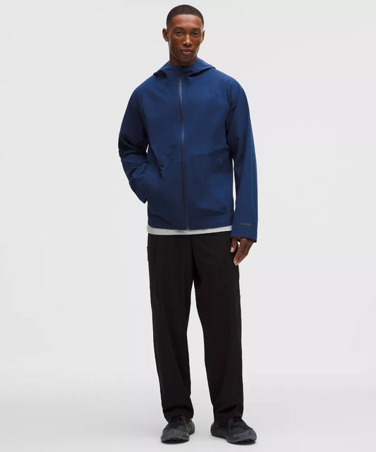 Man wearing a blue jacket and black pants on a white background