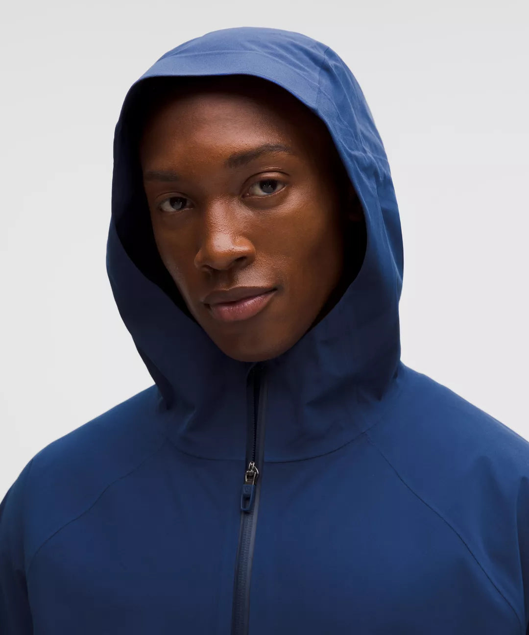 Person wearing a blue hooded jacket against a plain background