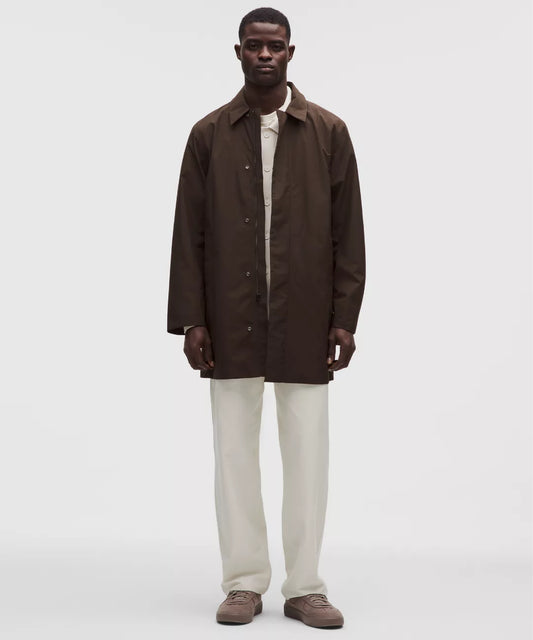 Man wearing a brown coat over a white shirt on a white background