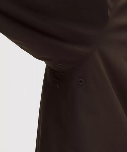 Close-up of a dark brown coat with button details on a light gray background