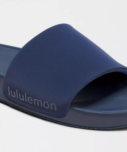 Navy blue slide sandal with 'lululemon' branding on a light gray background