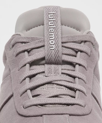 Close-up of a gray sneaker with laces and 'Puma' branding.