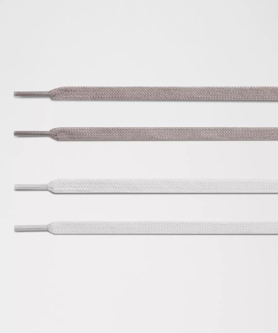 Three pairs of white shoelaces on a light gray background
